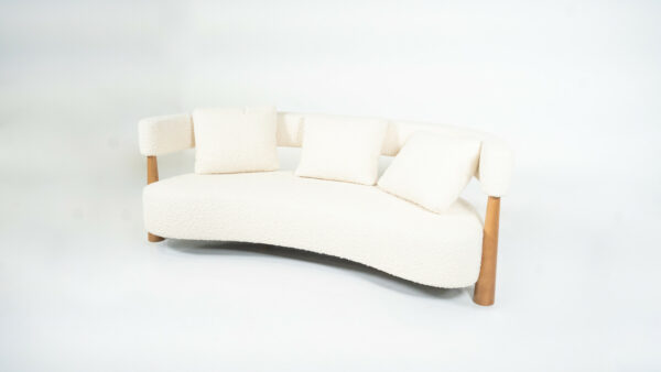 Contemporary Italian bean-shaped sofa with white bouclé upholstery, curved design, and wooden legs